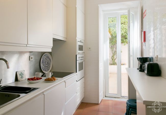 cozinha de alto padrão com forno, microondas, fogão elétrico que abre para um pátio interior acolhedor e florido