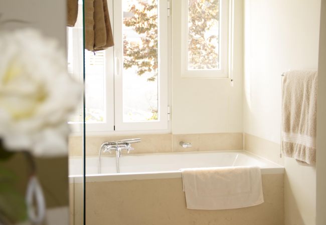 banheiro com banheira em tons puros com vista para o pátio interior