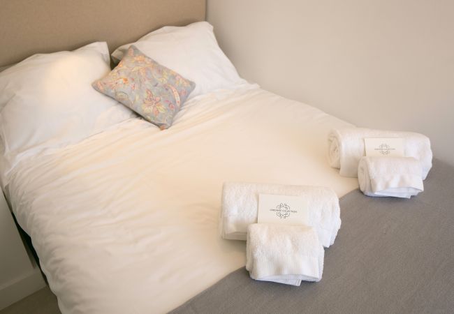 Cama de casal com toalhas dobradas na cama no centro histórico de Lisboa 