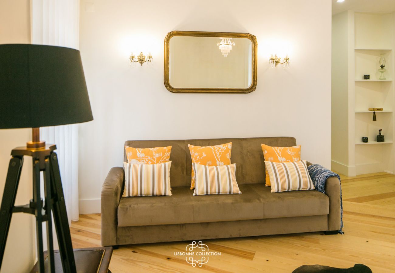 sala de estar com sofá, lâmpada de design e parquet antigo em Lisboa
