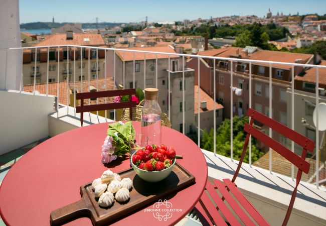 terraço mobilado com mobiliário vermelho e amplo panorama de Lisboa